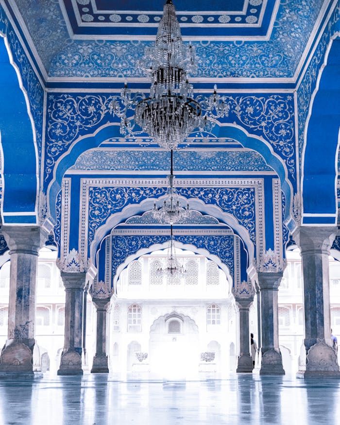 Intricate blue interior architecture of Jaipur City Palace, showcasing traditional design and chandeliers.