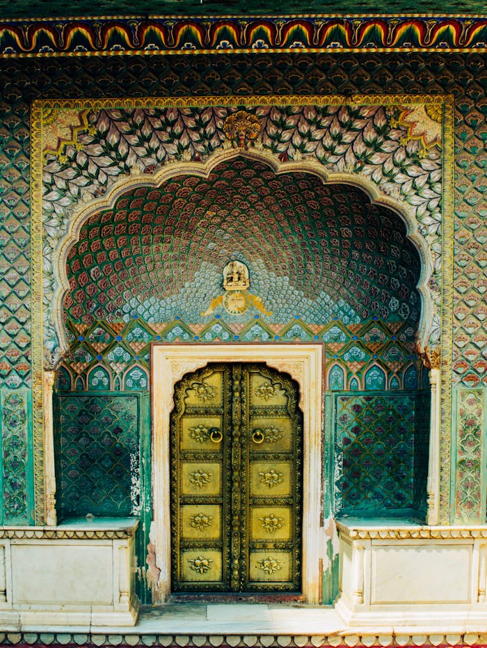 Intricate facade with ornate doors, showcasing vibrant traditional Indian design patterns.